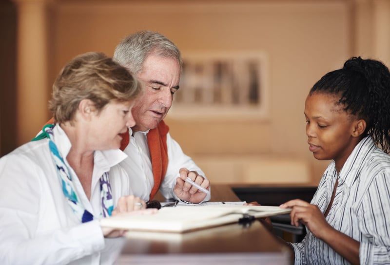 People looking at paperwork at a counter