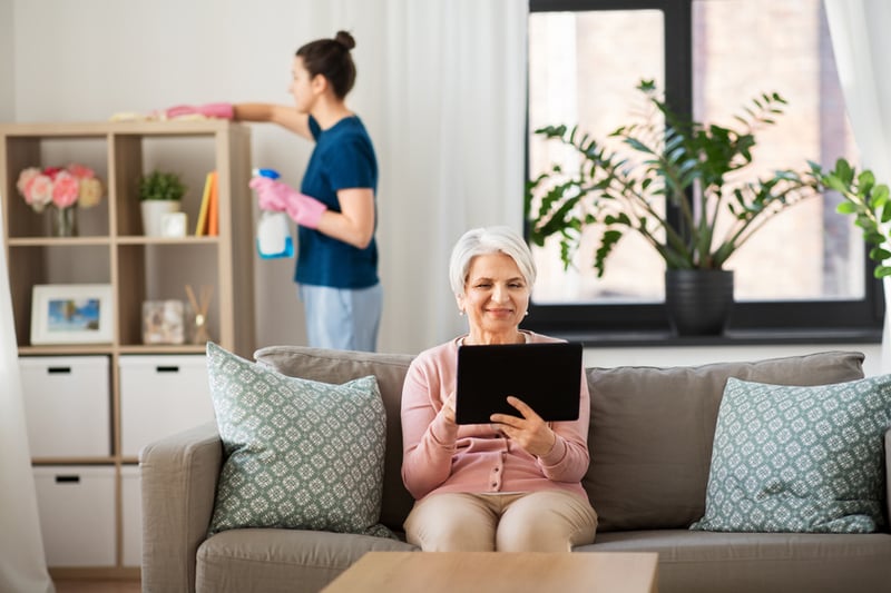 Senior sitting on a couch using a tablet
